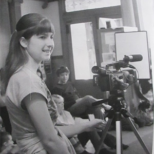 photo of irene case standing next to a camera