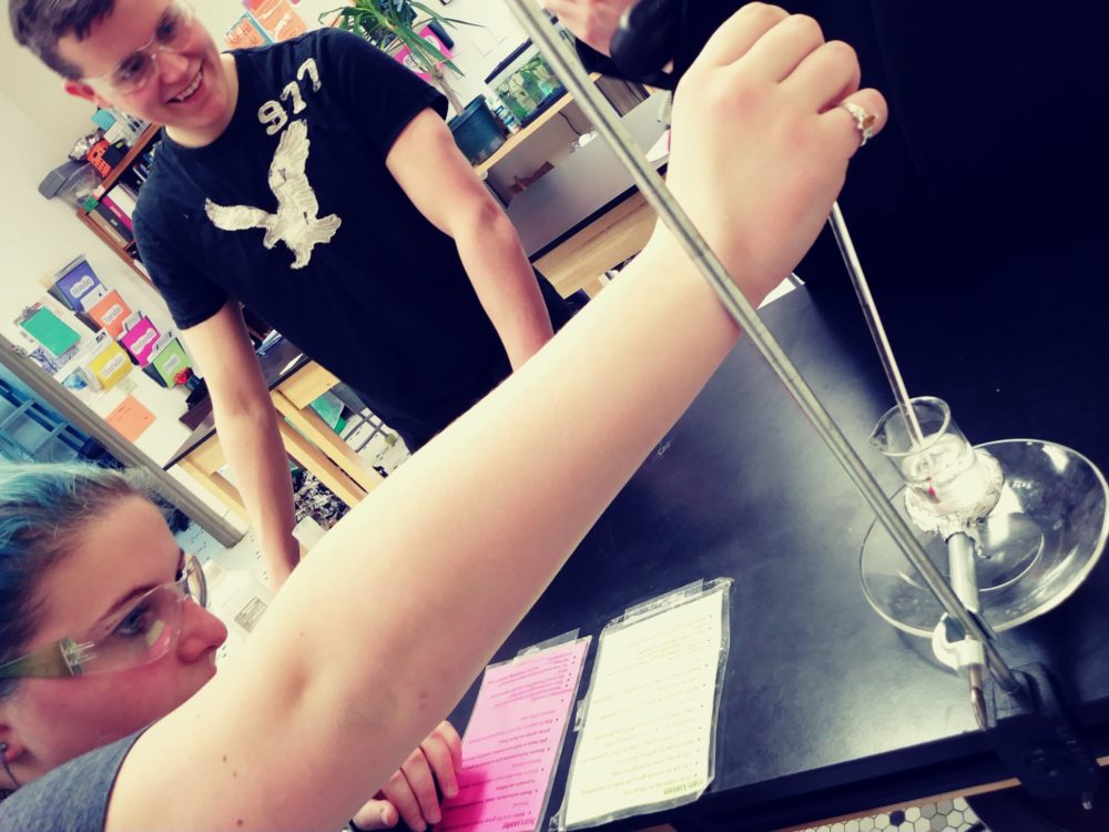two students in a science lab conducting an experiment
